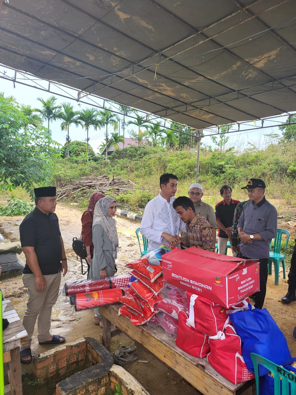 Pj Bupati Muaro Jambi Bachyuni saat menyerahkan bantuan kepada orang tua korban kebakaran 